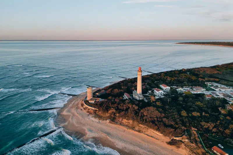 Vue aérienne d'une villa sur la plage avec un phare