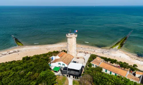 Vue aérienne d'une villa sur la plage avec un phare