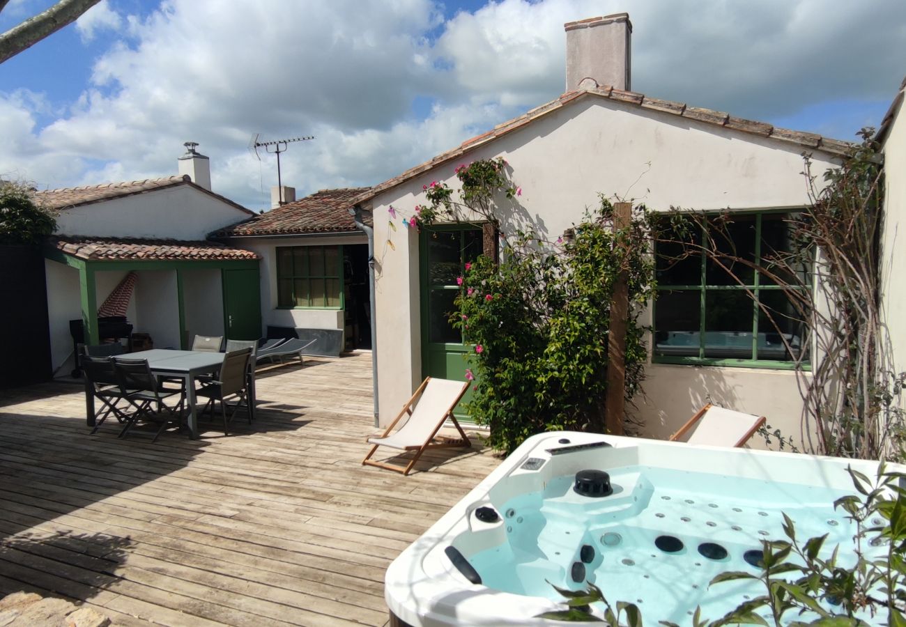 Outside view of the jacuzzi, the terrace with deckchairs and the outbuilding