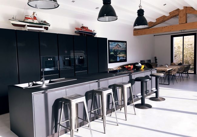 Modern grey fully equipped kitchen with long central island 