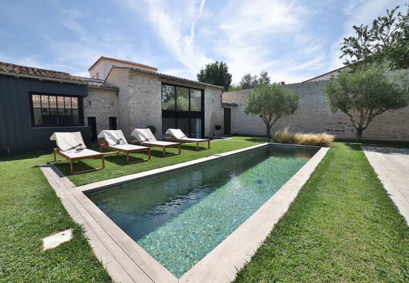 Swimming pool with sun loungers and the house behind