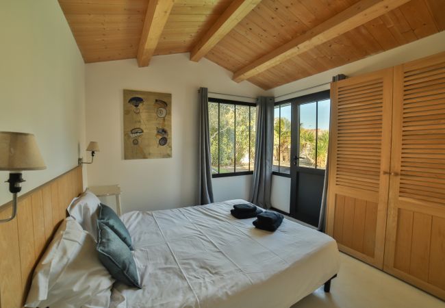 Bedroom with double bed and large windows 