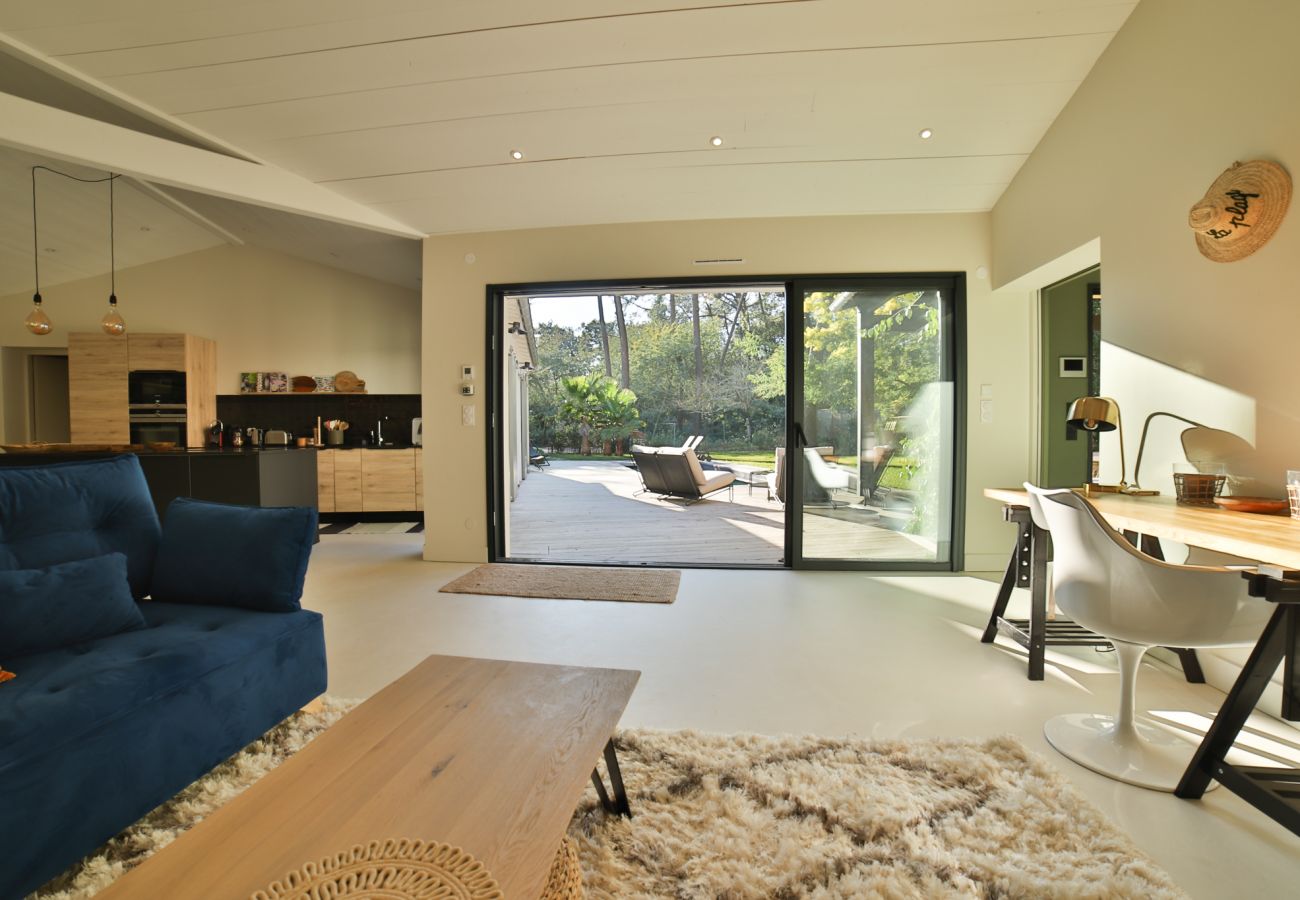 Living room with blue sofas, wooden coffee table and garden view