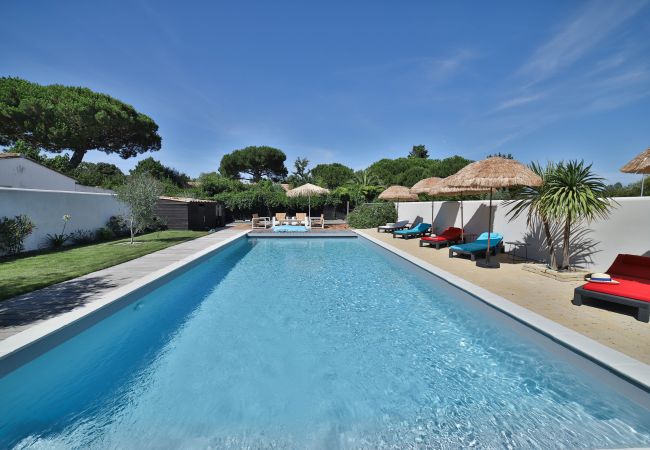 Overlooking the pool with straw loungers and parasols