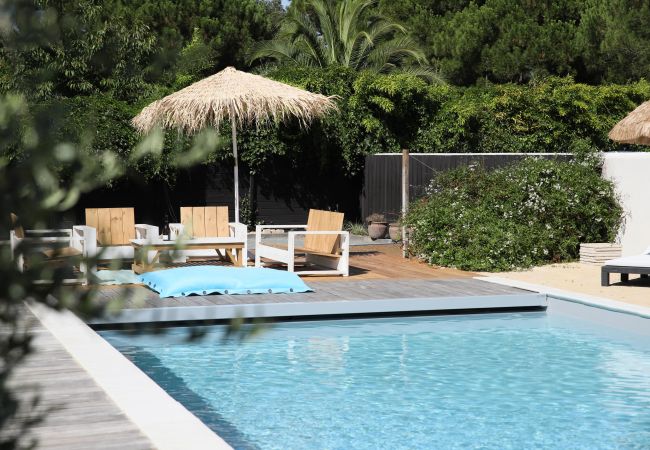 View of the outdoor living room, the green garden and the pool 