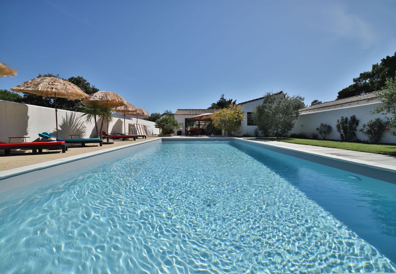 Overlooking the pool with straw loungers and parasols