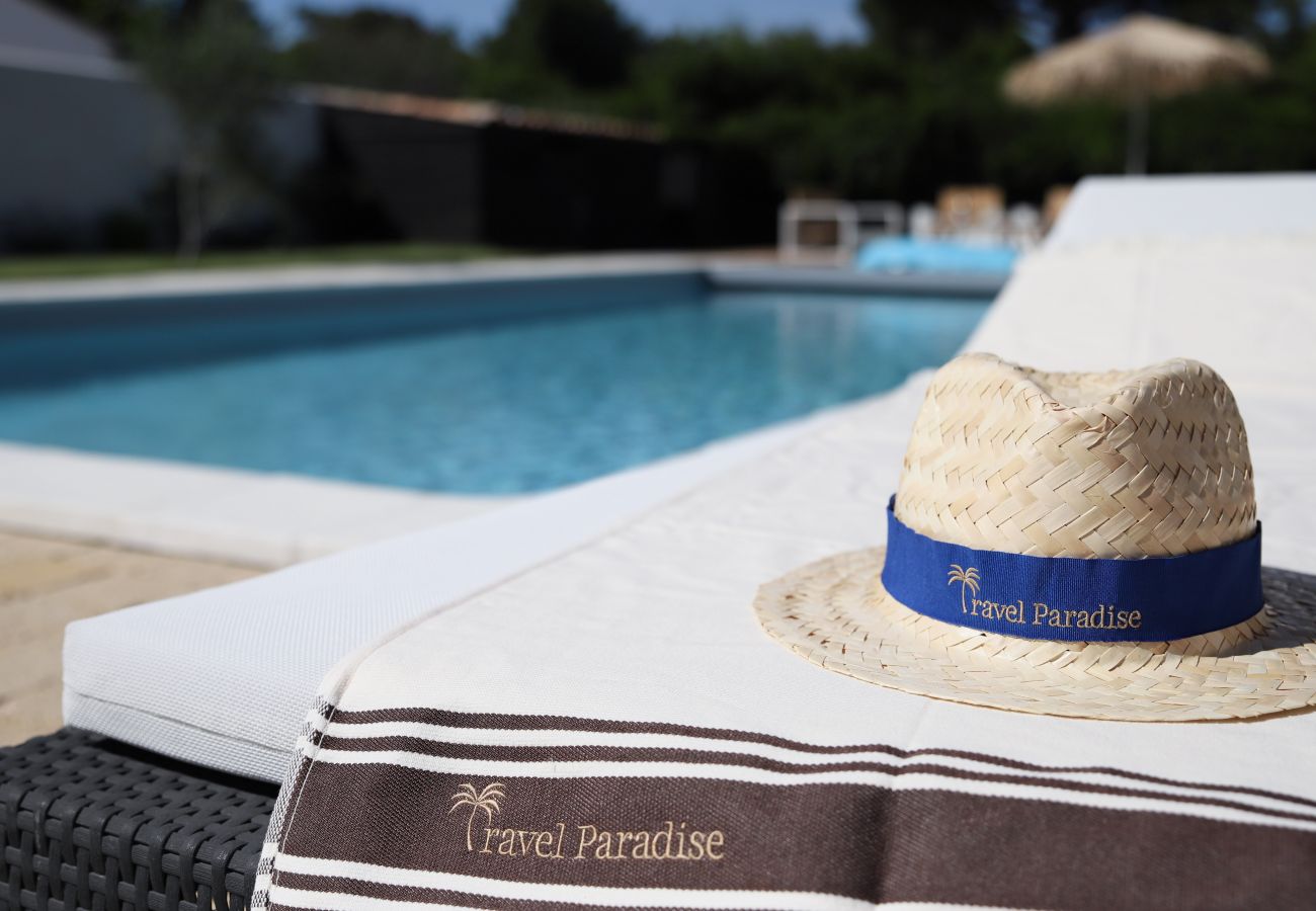 View of the pool, straw hat and towel 