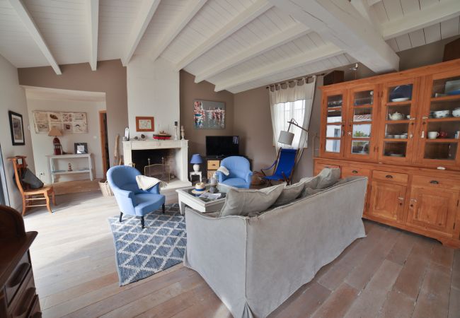 The living room with sofas, armchairs, fireplace and exposed white beams 