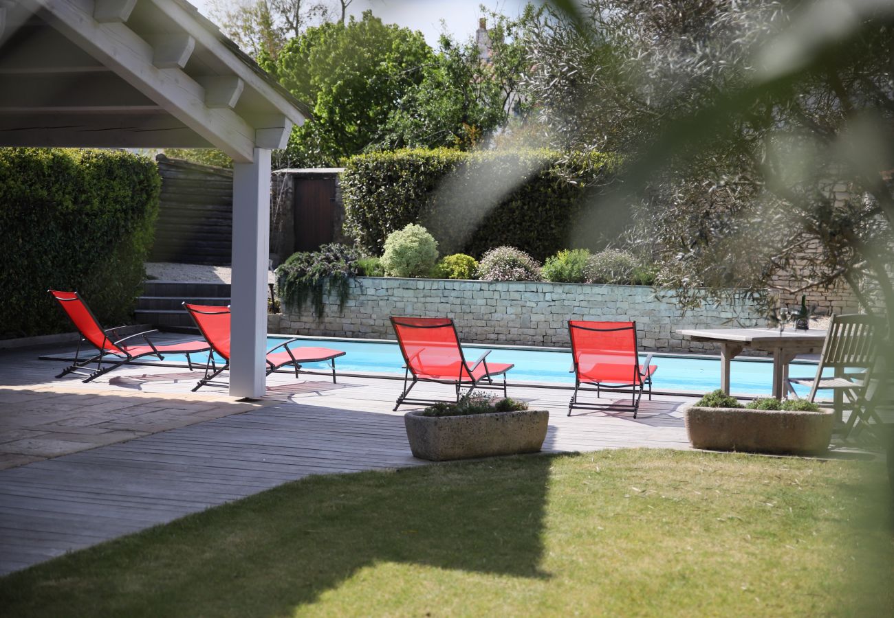 View of the garden and large swimming pool with sun loungers