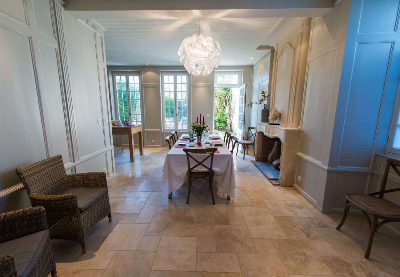 The dining room with a large table, chairs and a view of the garden 