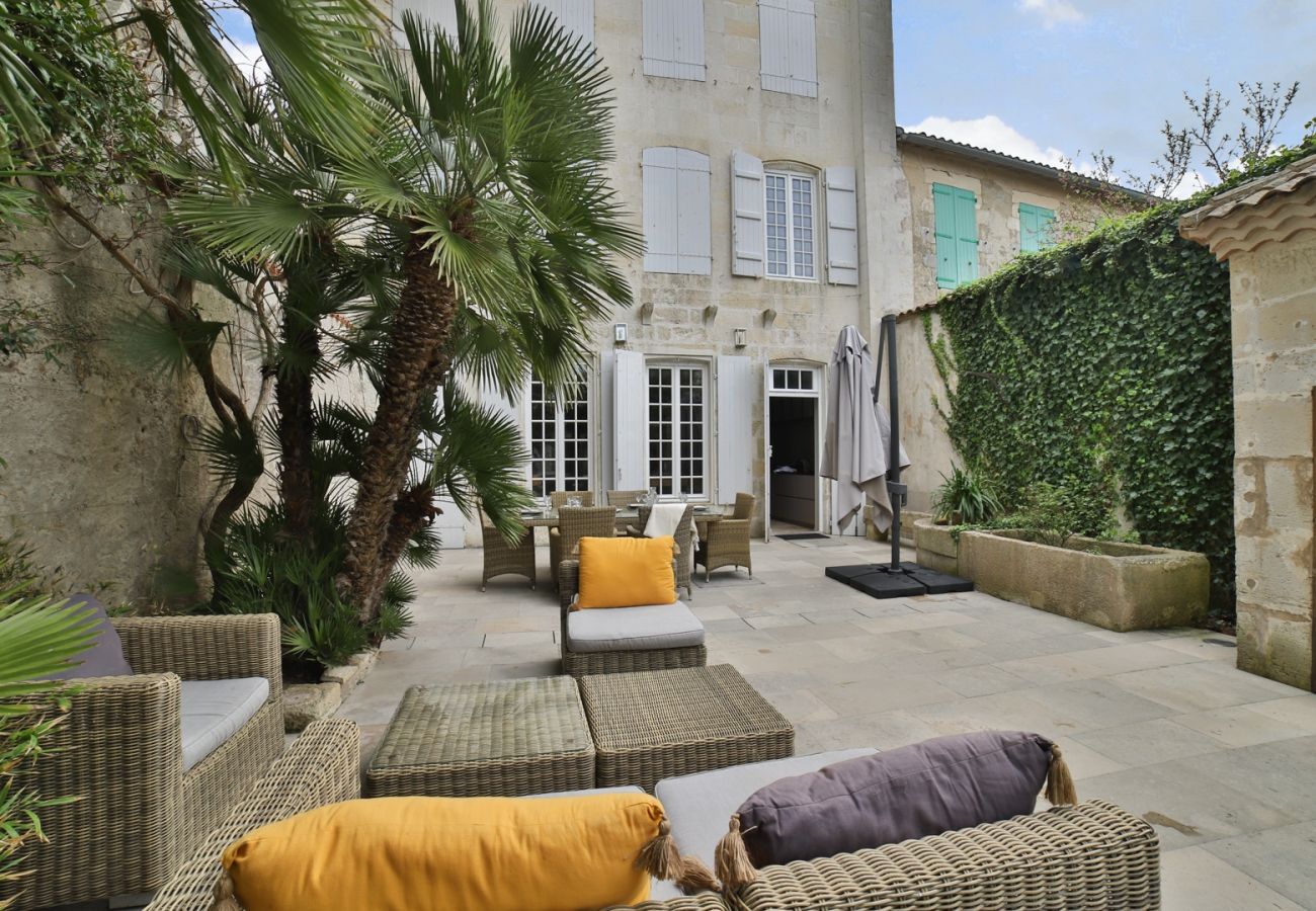The large terrace with garden furniture, dining table and palm trees 