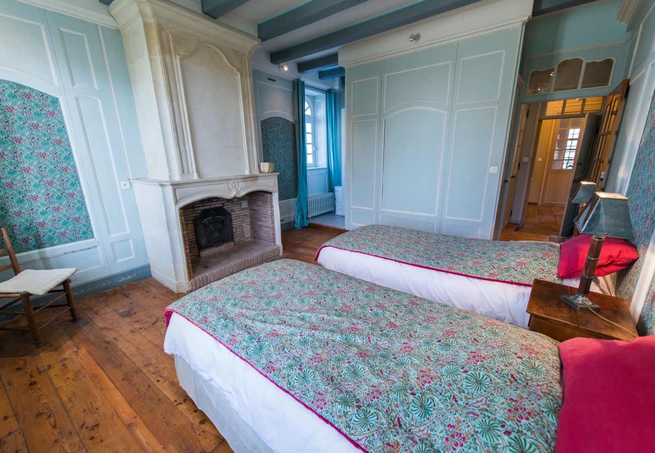 Room with two double beds and fireplace