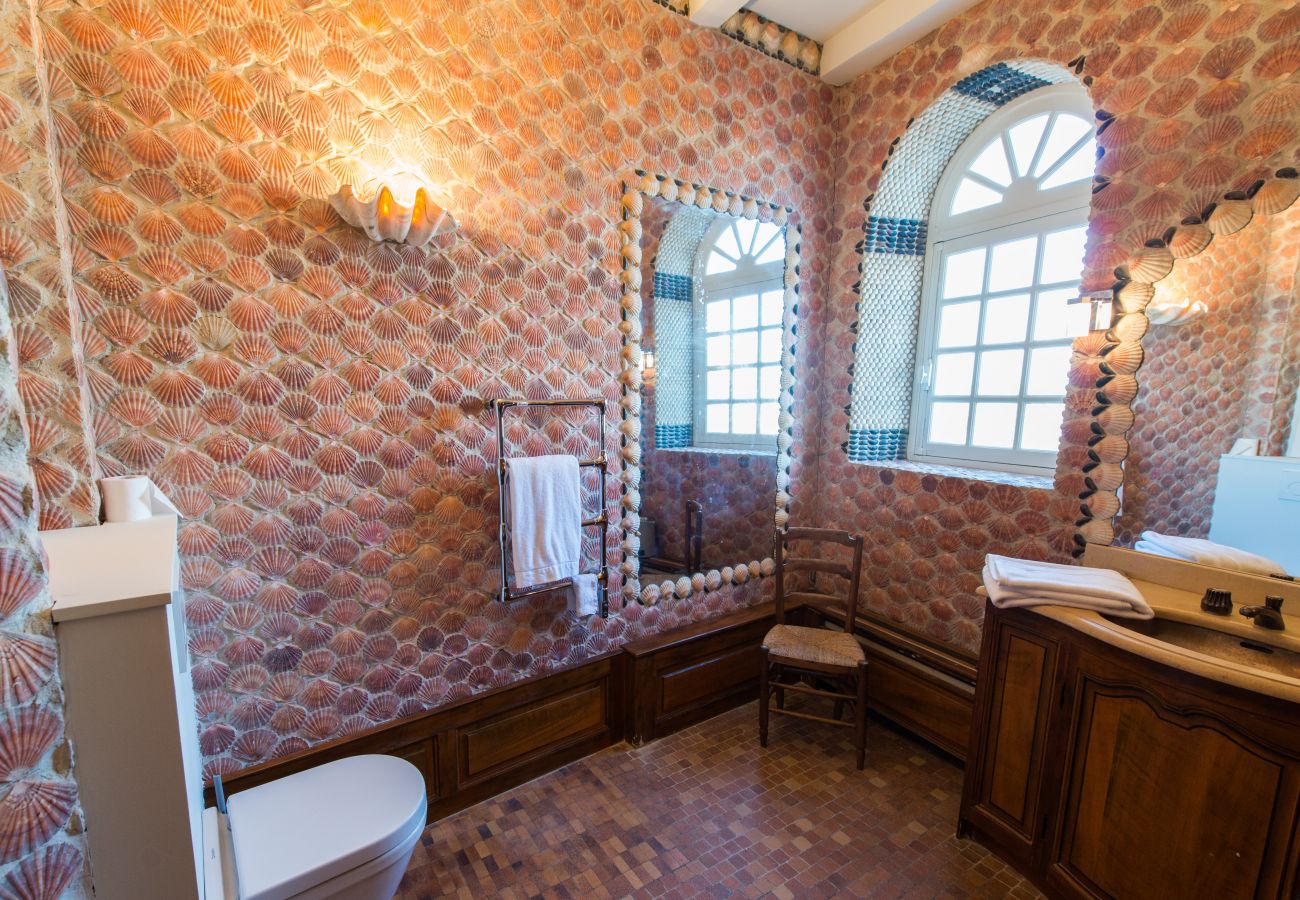 Bathroom decorated with shells and toilet 