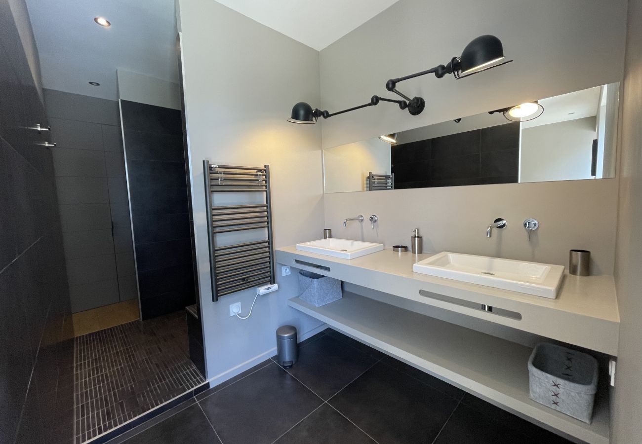 Grande salle de bain moderne avec douche italienne et deux vasques 