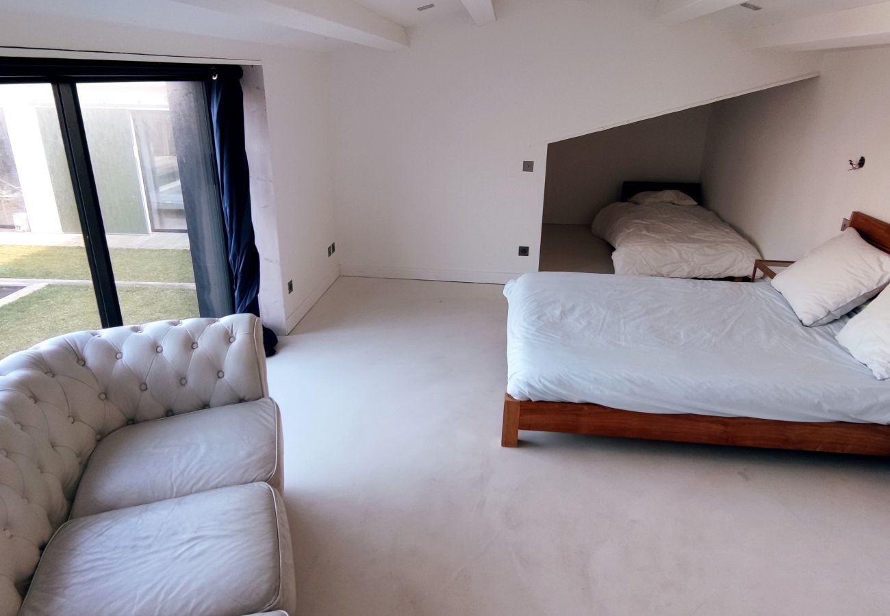 Grande chambre avec lit double, lit simple et grand canapé 