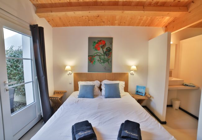 La chambre à coucher avec lit double et plafond en bois avec poutres 