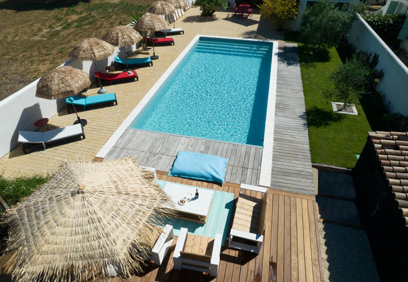 vue aérienne sur la piscine, la terrasse avec salon extérieur et chaises longues 