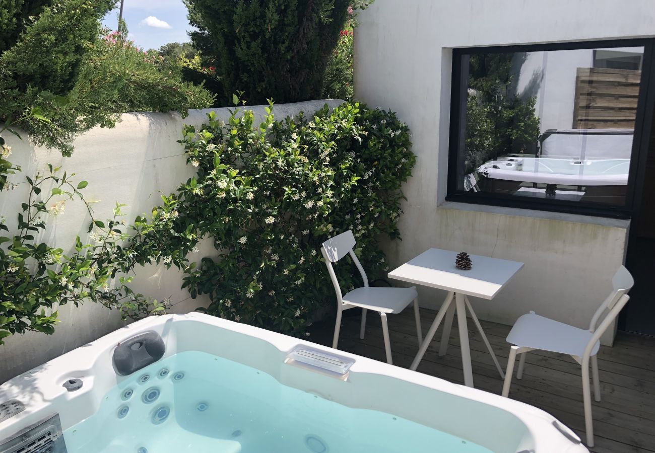 Terrasse en bois avec table et chaises et spa