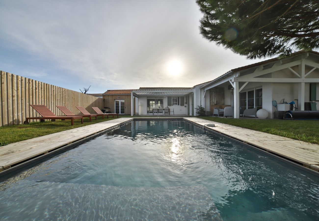 Le jardin avec piscine et chaises longues 