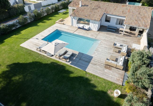 Vue aérienne sur la maison, la terrasse et la piscine 