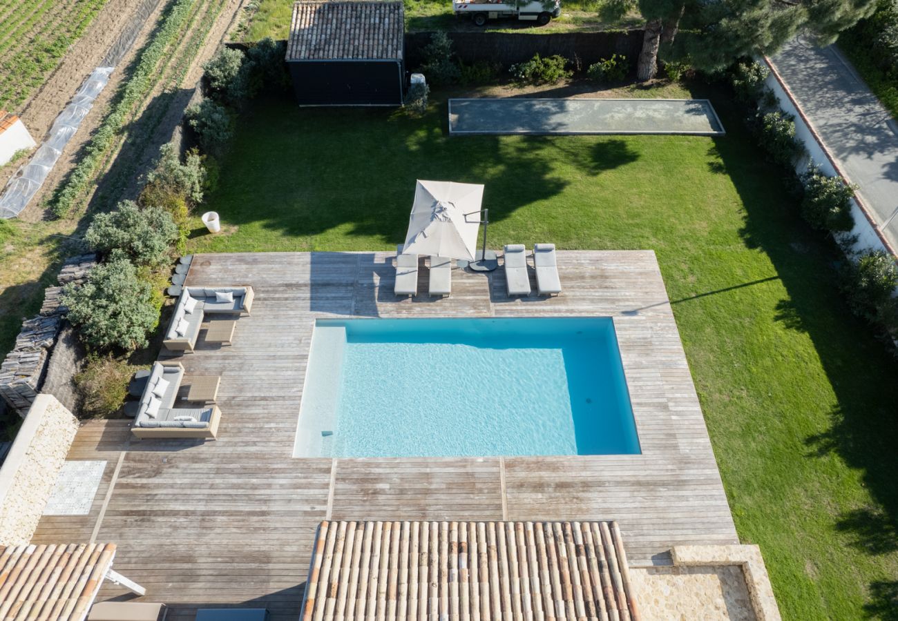Vue aérienne sur la maison, la terrasse et la piscine 