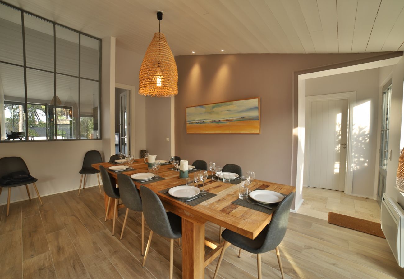 La salle à manger avec grande table en bois et les chaises 